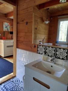 ein Badezimmer mit Waschbecken in einem Holzhaus in der Unterkunft Ulęgałki Roztocze in AdamÃ³w + 26 Fotos