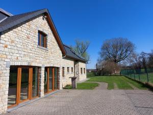 a brick building with wooden doors and a driveway at Villa VIP in Welkenraedt