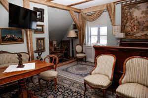 a living room with a table and chairs at Kukšu muiža in Kukšas