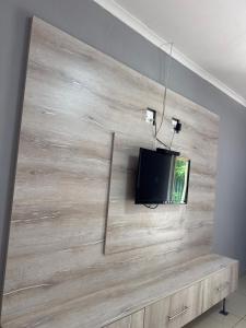 a tv on a wall with a wooden wall at Northam Square Mine Contractor Accommodation in Northam