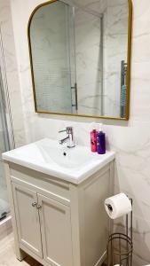 a bathroom with a white sink and a mirror at Little Gem in Swanage +34 photos