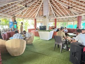 a group of people sitting at tables in a restaurant at Red Sea Beach Resort in Anjuna