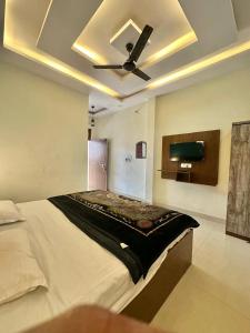a bedroom with a large bed with a ceiling fan at Riskla hotel Near-Ram Mandir 700M in Ayodhya