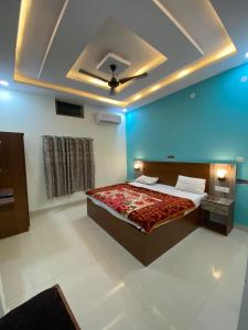 a bedroom with a large bed with a ceiling at Riskla hotel Near-Ram Mandir 700M in Ayodhya