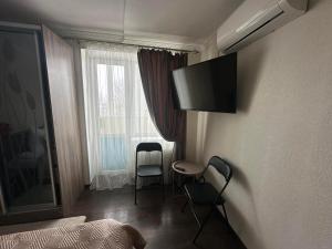 a hotel room with a bed and a table and chairs at Apartment in Zolotonosha