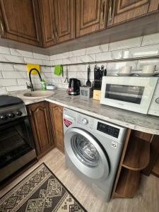 a kitchen with a washing machine and a microwave at Apartment in Zolotonosha +7 photos