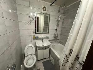 a bathroom with a toilet and a sink and a tub at Apartment in Zolotonosha