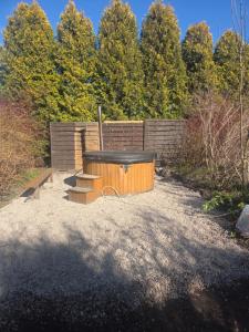 a hot tub in a yard with a fence at Plebanka in Grabowo +11 photos