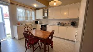 a kitchen with a wooden table and chairs in it at Vergi Apartments in Pyla