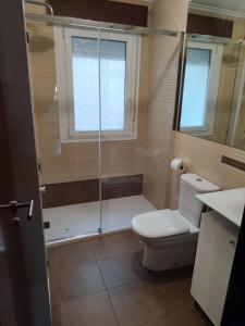 a bathroom with a toilet and a glass shower at Rego de Flores in Viveiro +27 photos