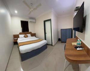 a hotel room with a bed and a table at Hotel Sunshine Airport in Mumbai