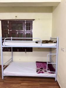 an empty bunk bed in a room with a window at Sainik Dormitory and Room Service in Lucknow