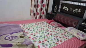 a bed with a blanket and pillows on it at Sainik Dormitory and Room Service in Lucknow