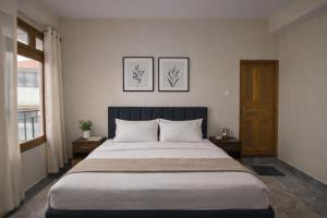 a bedroom with a large bed and two pictures on the wall at Himnest in Kalpa