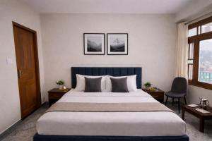 a hotel room with a large bed with two chairs at Himnest in Kalpa