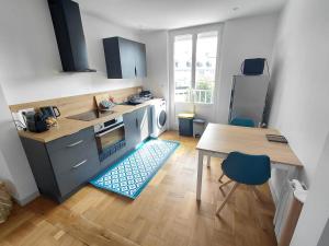 a small kitchen with a table and a table and chairs at Appartemement F2 refait à neuf hyper centre in Coutances