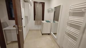 a white bathroom with a sink and a mirror at Casa Cappuccini in Comacchio