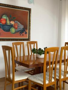 a wooden table with chairs and a bowl of fruit at Marl's Home in Berat