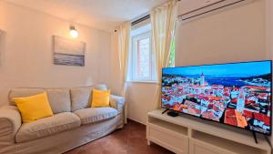 a living room with a couch and a flat screen tv at Old Town Stay by Ivo in Trogir