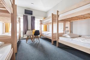 a room with three bunk beds and a desk at Polin House in Oświęcim