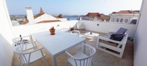 a white table and chairs on a balcony at Figueira Penthouse by the Marina in Figueira da Foz