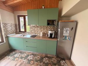 a kitchen with green cabinets and a refrigerator at Relax88 in Bran