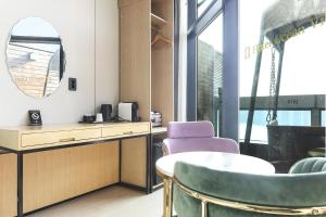 a room with a table and chairs and a mirror at Gwanganri HOTEL OCEANVIEW in Busan