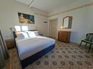 a bedroom with a bed and a dresser and a mirror at Villa Grappoli Apt MAGGIORE with lake view in Lesa