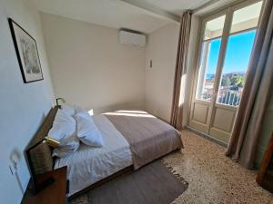 a bedroom with a bed and a large window at Villa Grappoli Apt MAGGIORE with lake view in Lesa