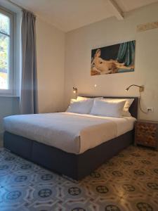 a bedroom with a bed in a room with a window at Villa Grappoli Apt MAGGIORE with lake view in Lesa