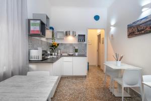 a kitchen with white cabinets and a table and chairs at Mellos B&B in Naples