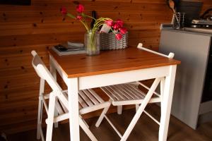 a table with two chairs and a vase with flowers at Skylark - Pod in Northrepps
