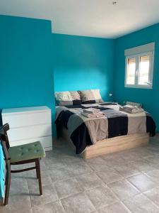 a blue bedroom with a bed and a chair at Casa Latina in Moralet +13 photos