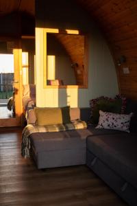 a living room with a couch and a mirror at Skylark - Pod in Northrepps