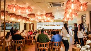 a group of people sitting at tables in a restaurant at Domingo Design Hotel in Santa Rosa de Calamuchita