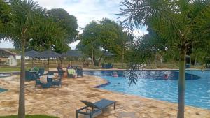 a pool with tables and chairs and people swimming at Day Use in Cascavel