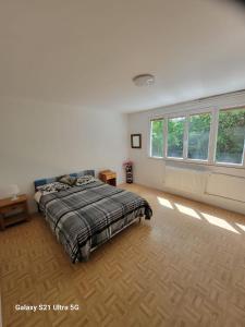 a bedroom with a bed in a room with windows at La Maison Bloom in Houilles
