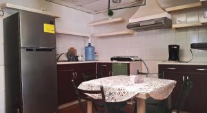 a kitchen with a table and a refrigerator at Casa Mary in Panajachel