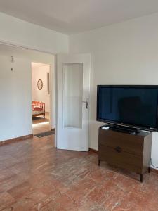 a living room with a flat screen tv on a dresser at La Maison Bloom in Houilles