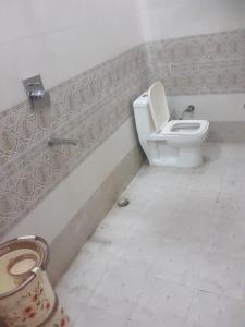 a bathroom with a toilet and a sink at Maharani Garden in Haldwāni
