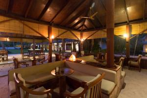 a restaurant with a couch and tables and chairs at Filitheyo Island Resort in Filitheyo
