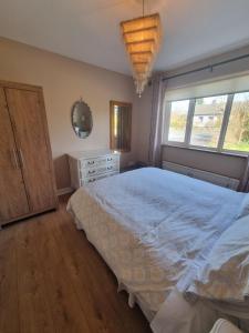 a bedroom with a bed and a dresser and a window at Rosemount in Sligo +19 photos