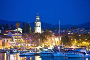 a group of boats docked in a harbor with a clock tower at Keti House Apartments in Vela Luka