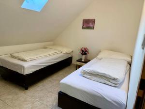two beds in a small room withermottermottermott at Ubytovna u Maiky in Libochovice