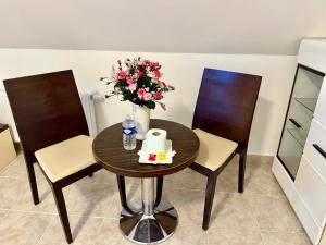 a table and two chairs with a vase of flowers at Ubytovna u Maiky in Libochovice +10 photos