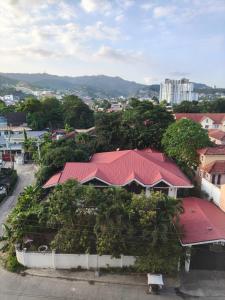 a building with a red roof with trees around it at Urban Oasis Symphony Pool in Cebu City