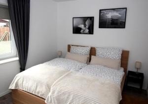 a bedroom with a bed and two pictures on the wall at 2 Exklusive Ferienwohnungen an der Nordsee in Bremerhaven