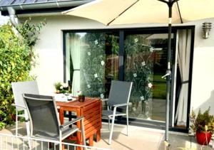a patio with a table and chairs and an umbrella at 2 Exklusive Ferienwohnungen an der Nordsee in Bremerhaven
