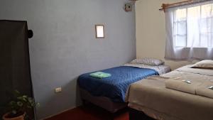 a bedroom with two beds and a window at Casa Mary in Panajachel +17 photos