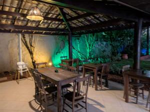 a dining room with tables and chairs and a green wall at Pousada Stella Tropical in Salvador